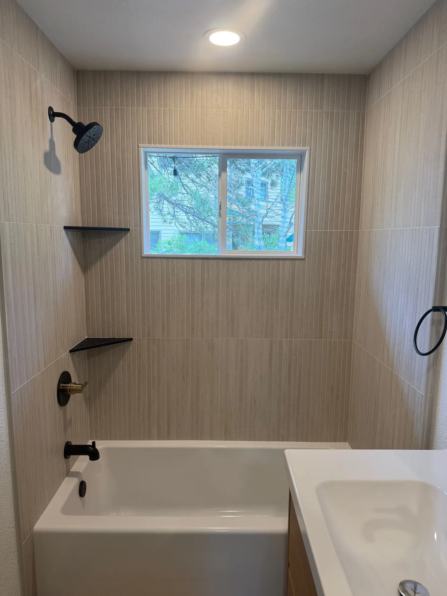 Tub-shower surround in vertical linen-texture large-format tile