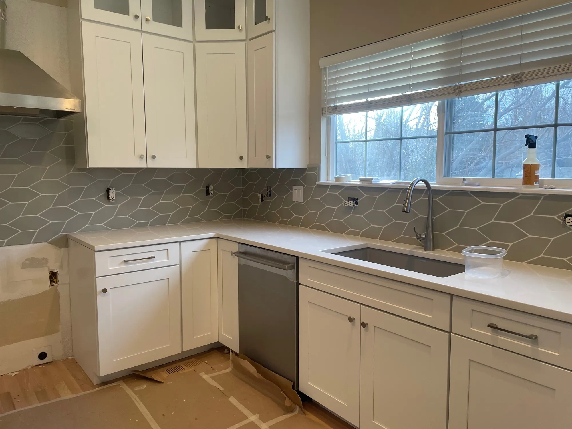 Gray elongated-hexagon picket tile backsplash with white shaker cabinets